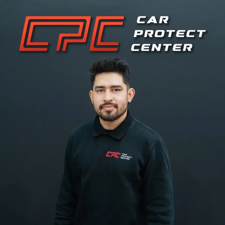 Portrait de studio d’un membre de l’équipe Car Protect Center, de face, devant le mur au logo CPC