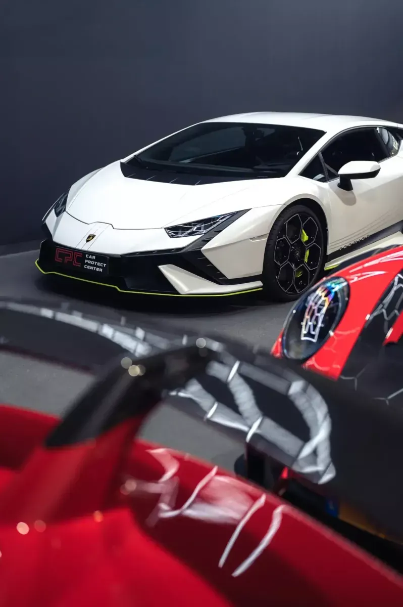 Lamborghini blanche vue par-dessus la carrosserie miroir d’une sportive rouge fraîchement polie